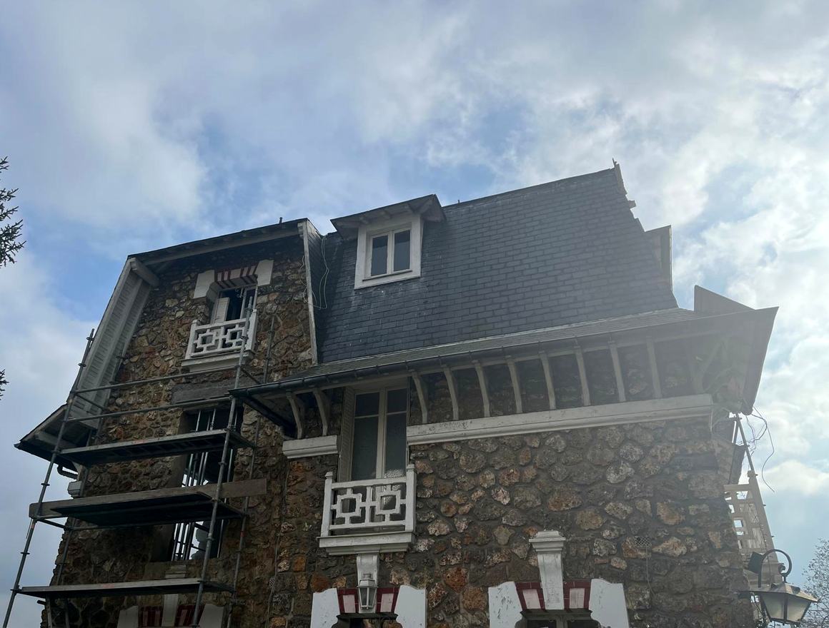 Maison en pierre sous échafaudage pendant la réfection de sa toiture en ardoise, chantier de Couv'Clou, couvreur à Clouange